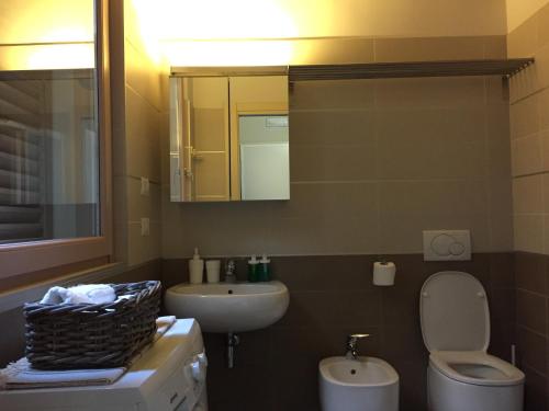 a bathroom with a sink and a toilet and a mirror at Niki O. Apartments in Parma
