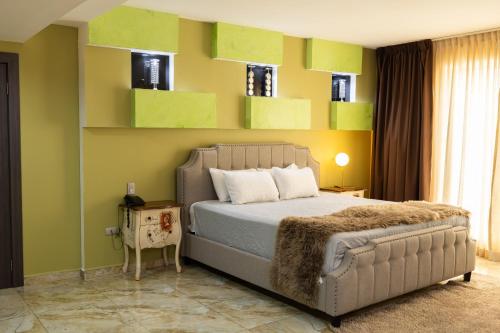 a bedroom with a bed with green and yellow walls at Basha Hotel & Restaurant in San Pedro Sula