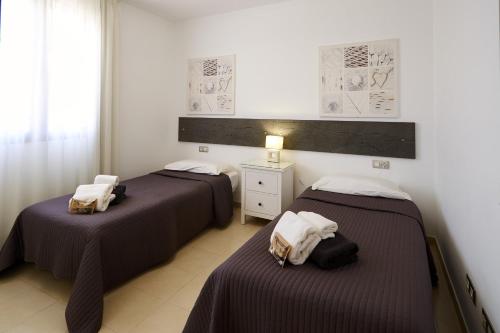 a room with two beds and a dresser at Villa Bella Valen - LH170 By Villas Now Ltd in Playa Blanca