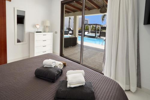 a bedroom with a bed with two pillows and a mirror at Villa Bella Valen - LH170 By Villas Now Ltd in Playa Blanca