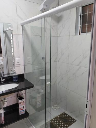 y baño con ducha de cristal y lavabo. en Rifugio en Alto Paraíso de Goiás