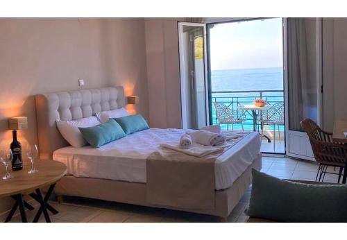 a bedroom with a large bed and a balcony at Sunset Premium Studio 6 in Agios Nikitas