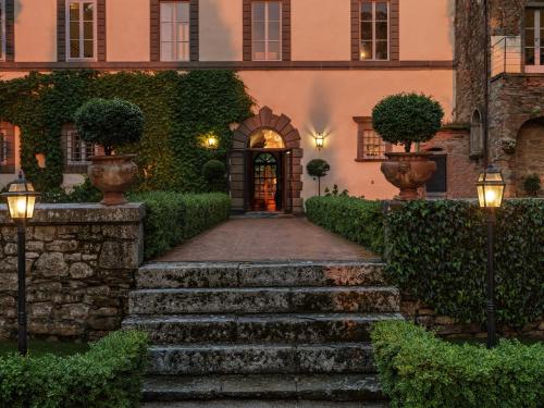 a walkway leading to a house with lights at Villa di Piazzano - Small Luxury Hotels of the World in Cortona