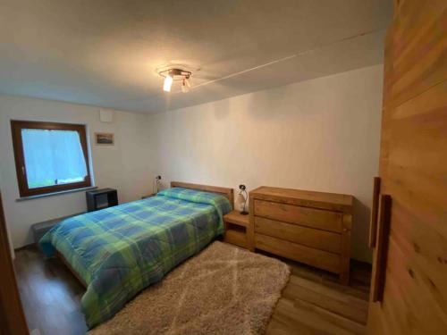 a bedroom with a bed and a window and a rug at Appartamento sul Lago di Maen in Valtournenche