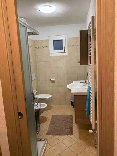 uma casa de banho com um lavatório e um WC em Appartamento sul Lago di Maen em Valtournenche