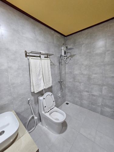 a bathroom with a toilet and a sink at White Sand Inn in Maamigili