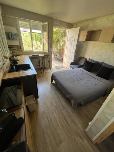 a bedroom with a bed and a kitchen with a sink at Chalet dans les arbres in Nice