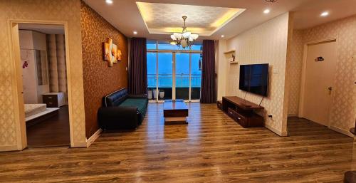 ein Wohnzimmer mit einem Sofa und einem TV in der Unterkunft H1 Passion in Ho-Chi-Minh-Stadt