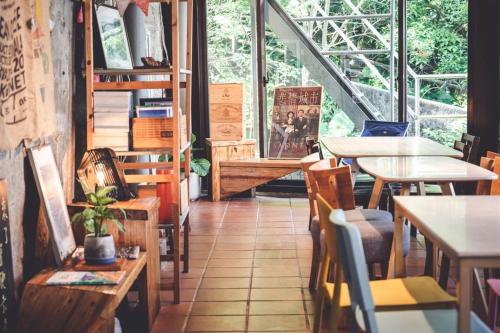 un restaurante con mesas y sillas y una gran ventana en Taipei Jinguashi Cloud Mountain Homestay B&B en Jiufen