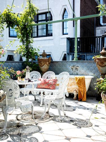 a patio with white chairs and a table and a fountain at Private and chique Salon de Franz in Amsterdam