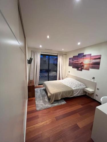 une chambre avec un lit et une grande fenêtre dans l'établissement Splendide villa avec piscine et salle cinéma, au Grau-dʼAgde