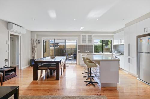a kitchen and living room with a table and chairs at Central Townhouse For Six by Ready Set Stay in Cowes