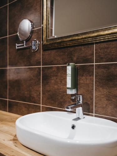 a bathroom with a white sink and a mirror at Hotel Victoria by VAYA in Kaprun