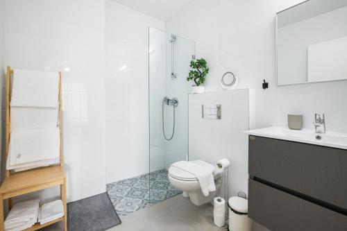 uma casa de banho branca com um WC e um chuveiro em Skyline Oasis by TLV2RENT em Tel Aviv