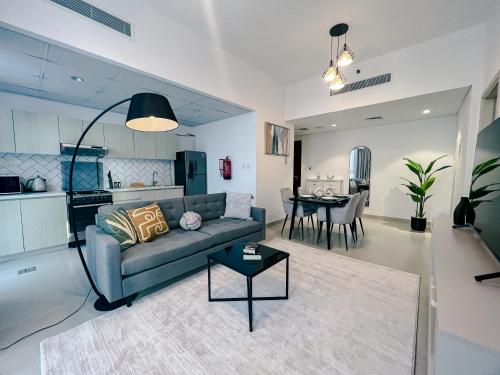 a living room with a couch and a table at Green community - Tennis, streetball - 15 mins sea in Dubai