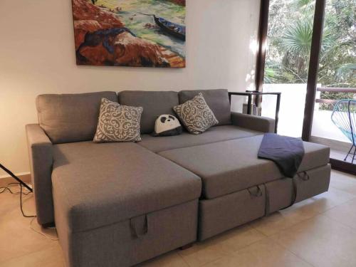 a brown couch with pillows on it in a living room at Aku-Chic Newly furbished condo Jungle pool in Xetna