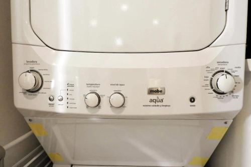 a washer and dryer with three knobs on it at Aku-Chic Newly furbished condo Jungle pool in Xetna