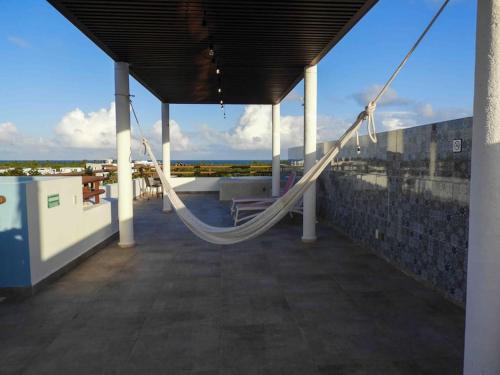 a porch with a hammock on top of a building at Aku-Chic Newly furbished condo Jungle pool in Xetna