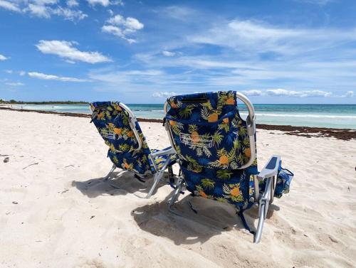 two chairs sitting in the sand on the beach at Aku-Chic Newly furbished condo Jungle pool in Xetna