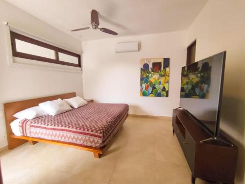 a bedroom with a bed and a ceiling fan at Aku-Chic Newly furbished condo Jungle pool in Xetna