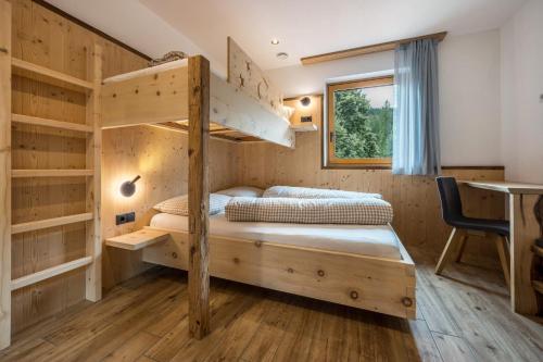 1 dormitorio con 2 literas y escritorio en Forchnerhof Apt 1, en Terento