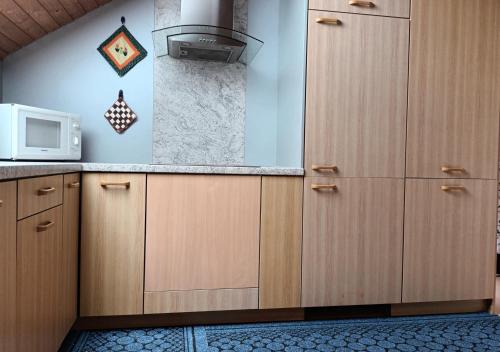 a kitchen with wooden cabinets and a microwave at Ferienwohnung Luise in Trossingen