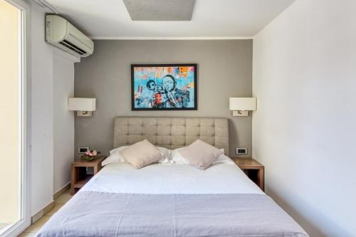 a bedroom with a white bed with two night stands at Hotel Villa d'Elsa in Juan-les-Pins