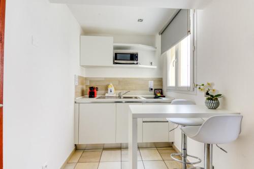 a white kitchen with a sink and a counter at Hotel Villa d'Elsa in Juan-les-Pins