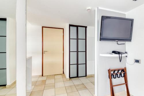 a room with a flat screen tv on a wall at Hotel Villa d'Elsa in Juan-les-Pins