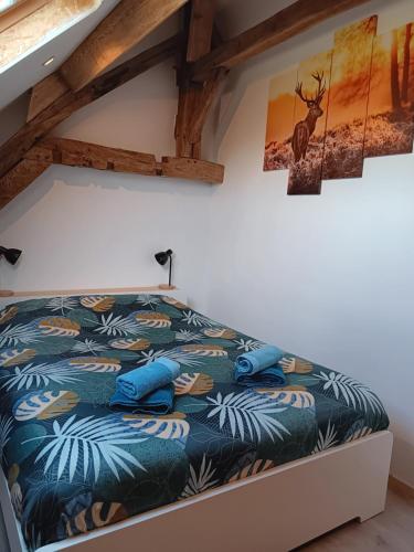 una camera da letto con letto e cuscini blu di Le Temps d'un Souffle - Gîte rural 3 épis a Sivry