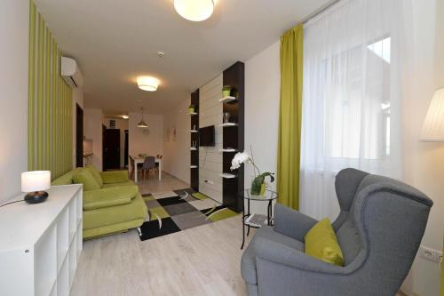 a living room with two chairs and a couch at Aranymandula apartmanok in Balatonakali