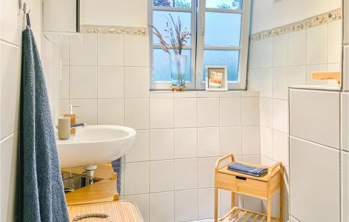 a white bathroom with a sink and a window at 1 Bedroom Beautiful Apartment In Morschen in Morschen