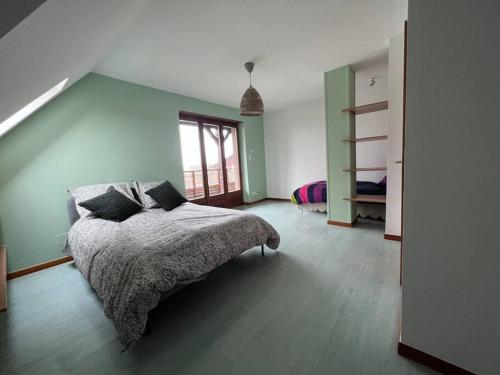 1 dormitorio con cama y pared verde en Appartement Stotzheim La Romaine, en Stotzheim