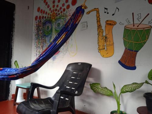 a black chair sitting in front of a wall with a painting at The Blues in Alleppey