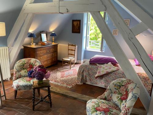 een slaapkamer met een bed en twee stoelen bij maison de charme à 1h 30 de Paris in Saint-Éman