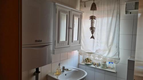 a bathroom with a sink and a mirror and a window at Pension Kapellenstraße - Ferienwohnung mit individueller Ausstattung - jedes Zimmer ist anders Komplette Küche in Erfurt