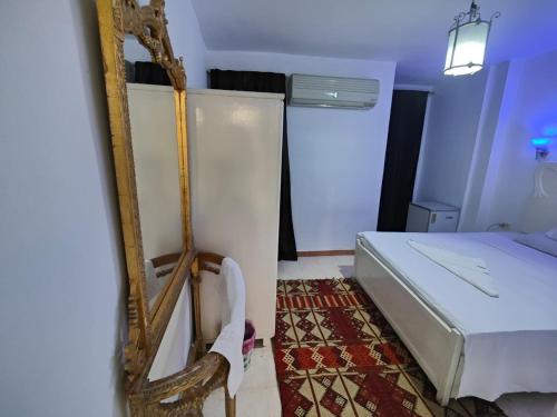 a small bedroom with a bed and a mirror at happy home in Luxor