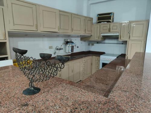 uma cozinha com armários brancos e um balcão de granito em happy home em Luxor