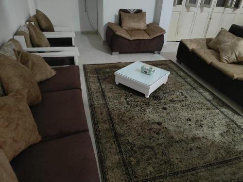 a living room with two couches and a coffee table at happy home in Luxor