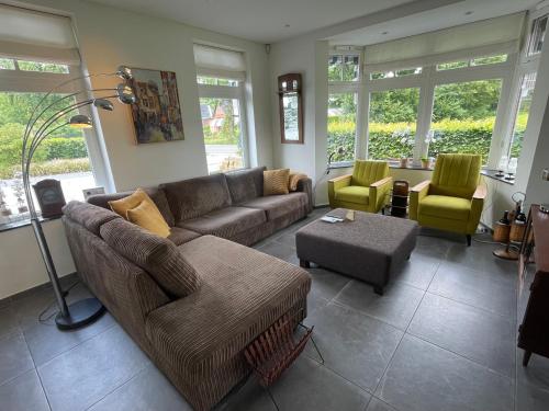 uma sala de estar com um sofá e duas cadeiras em Klein Nienoord Midwolde em Midwolde
