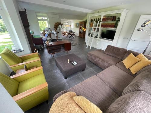 ein Wohnzimmer mit Couch und Sesseln in der Unterkunft Klein Nienoord Midwolde in Midwolde