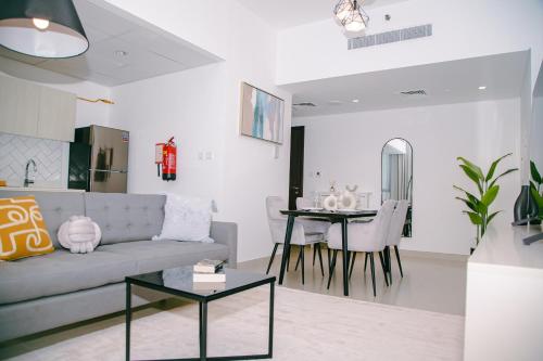 a living room with a couch and a table at Green community - Tennis, streetball - 15 mins sea in Dubai