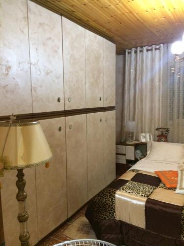 ein Schlafzimmer mit einem Bett und einem großen Schrank in der Unterkunft Sisi casa vacanze in Shkodra