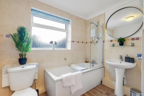 a bathroom with a toilet and a sink and a tub at Bourne Court Attractive 1 bedroom Apt by MDPS in Ruislip