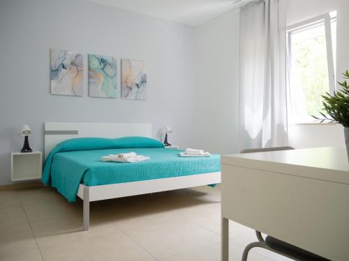 Un dormitorio blanco con una cama azul y una ventana en Dino's Rooms, en Lioni