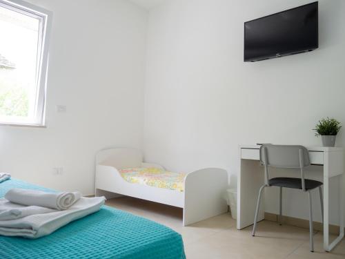 a bedroom with a bed and a desk and a tv at Dino's Rooms in Lioni