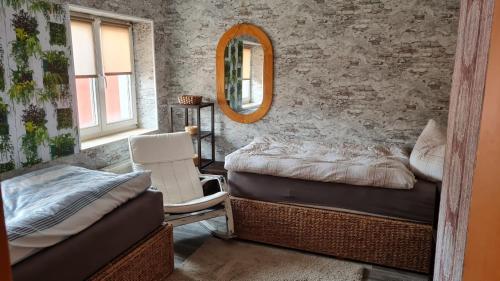 - une chambre avec 2 lits, un miroir et une chaise dans l'établissement Ferienwohnung mit individueller Ausstattung - jedes Zimmer ist anders, à Erfurt