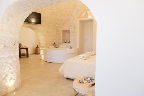 a bedroom with two beds and a bathroom with a sink at Iconica Luxury Suites in Alberobello