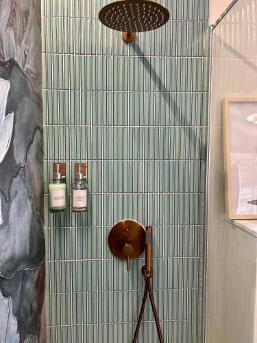 a shower with two bottles on a tiled wall at Ultracentral Lux Boutique 1BR Ap Near Subway in Bucharest