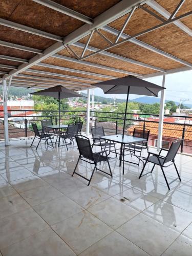 a group of tables and chairs with umbrellas at Loft atardecer in Uruapan del Progreso